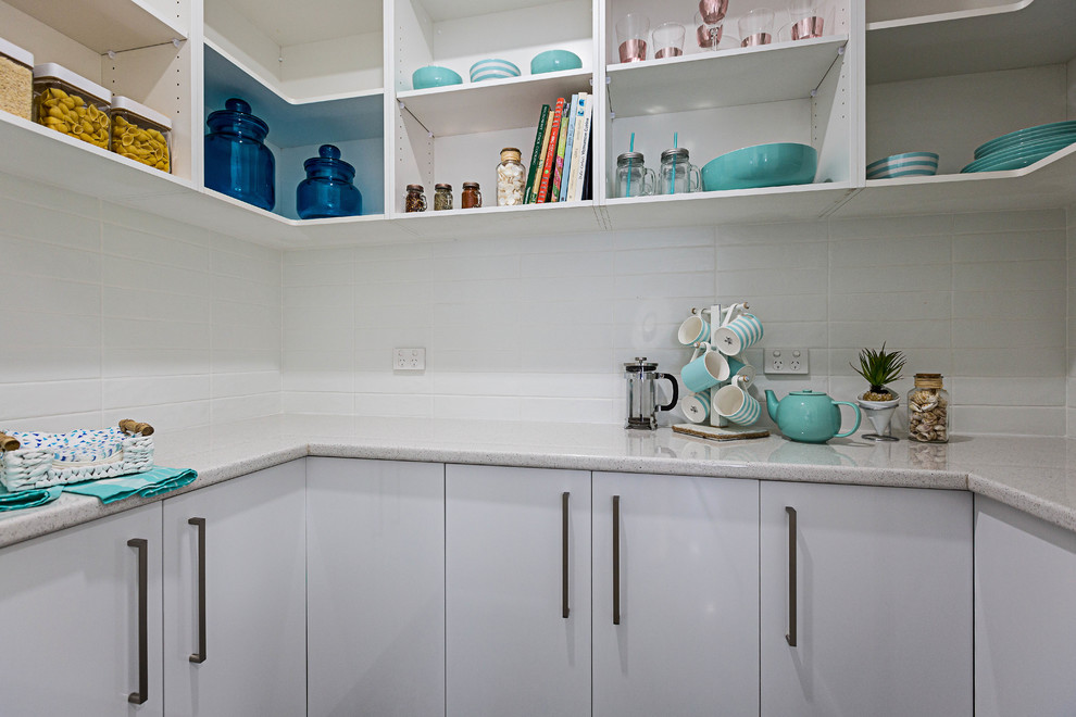 Foto di una cucina ad ambiente unico stile marinaro di medie dimensioni con ante bianche, top in granito, paraspruzzi bianco, paraspruzzi con piastrelle in ceramica e pavimento in cemento