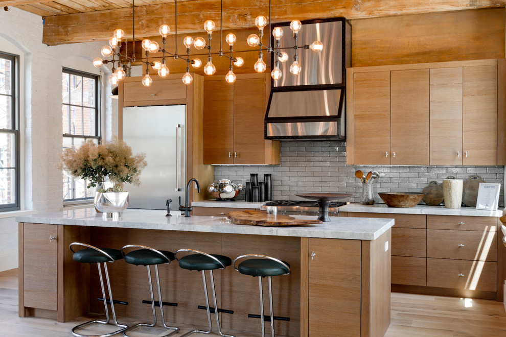 Example of a trendy galley light wood floor kitchen design in New York with flat-panel cabinets, medium tone wood cabinets, gray backsplash and an island
