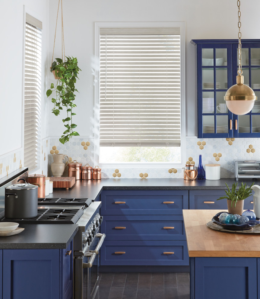 Photo of a medium sized traditional l-shaped kitchen in New York with shaker cabinets, blue cabinets, multi-coloured splashback, stainless steel appliances, an island, grey floors, engineered stone countertops, porcelain splashback and black worktops.