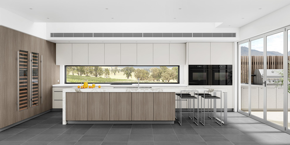 Large modern l-shaped open plan kitchen in Newcastle - Maitland with a submerged sink, flat-panel cabinets, medium wood cabinets, marble worktops, black appliances, slate flooring and an island.