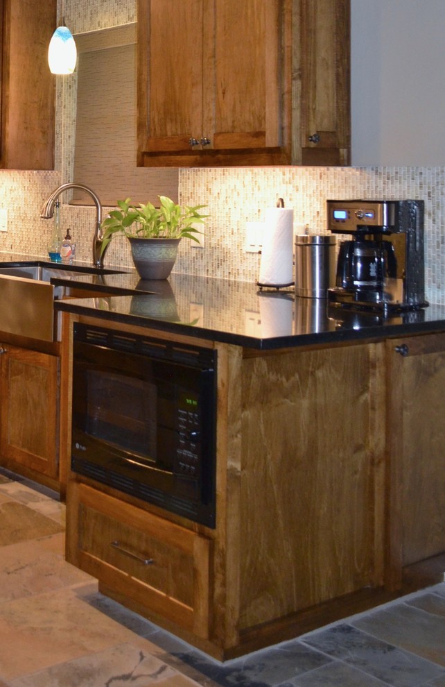 Exemple d'une petite cuisine parallèle nature en bois brun avec un évier de ferme, un placard à porte shaker, un plan de travail en granite, une crédence en carreau de verre, un électroménager en acier inoxydable et un sol en ardoise.
