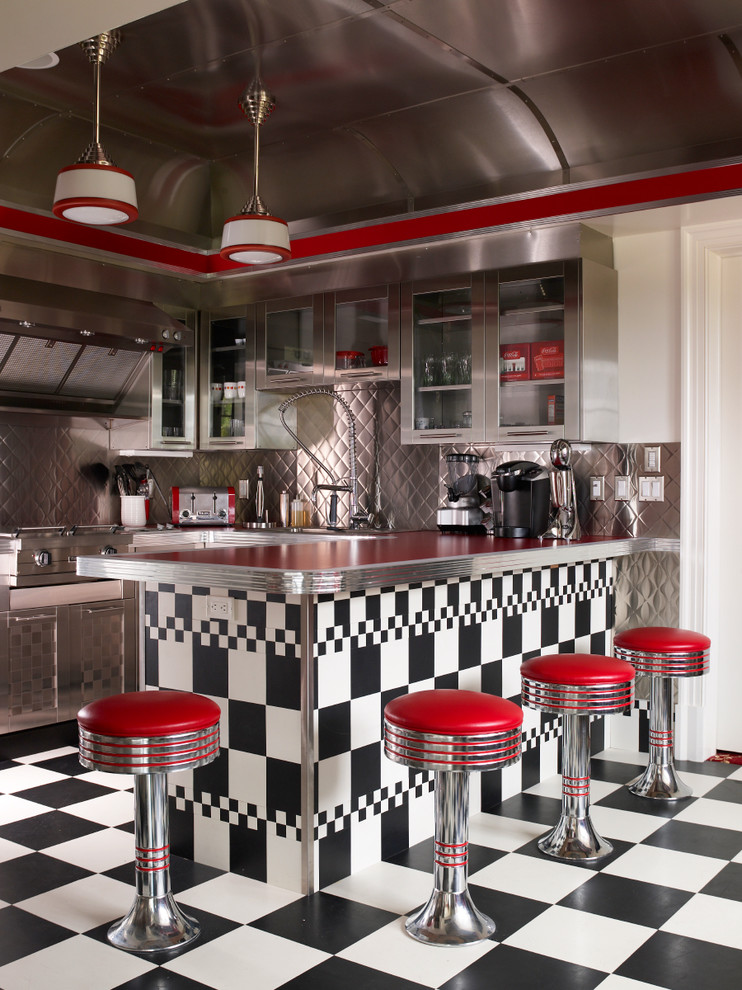 ニューヨークにあるエクレクティックスタイルのおしゃれなキッチン (メタリックのキッチンパネル、シルバーの調理設備、赤いキッチンカウンター) の写真