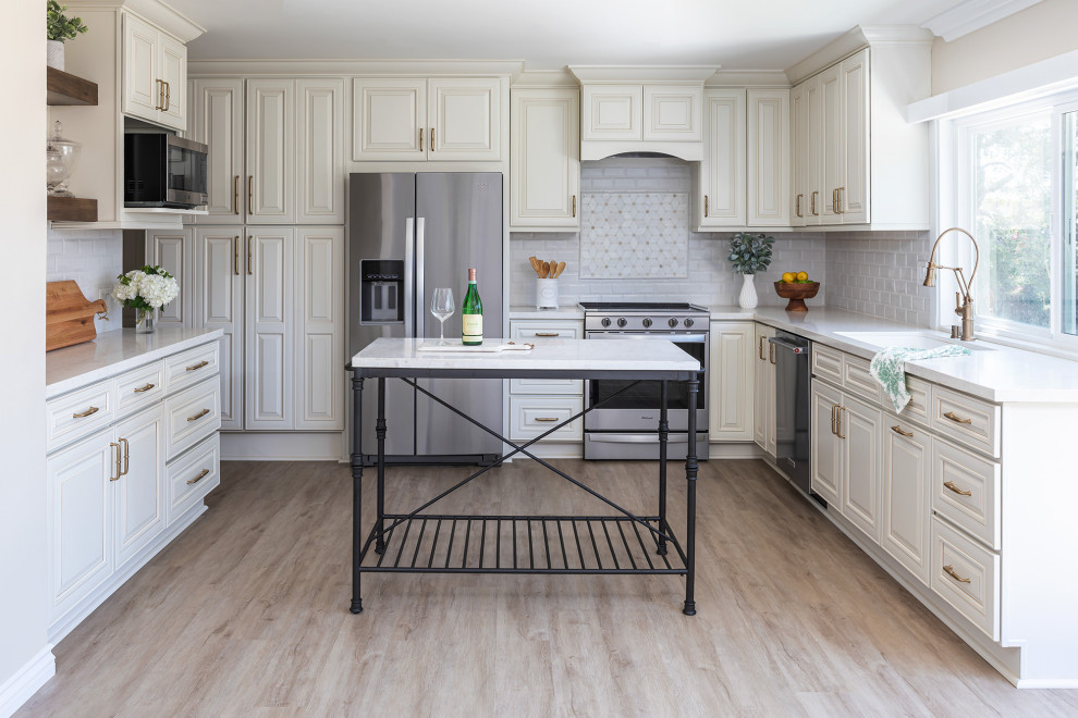 Foto di una cucina chic di medie dimensioni con lavello a vasca singola, paraspruzzi bianco, paraspruzzi in gres porcellanato, elettrodomestici in acciaio inossidabile e pavimento in vinile