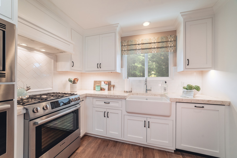 Small elegant eat-in kitchen photo in Orange County with a farmhouse sink, shaker cabinets, white cabinets, white backsplash, subway tile backsplash and stainless steel appliances