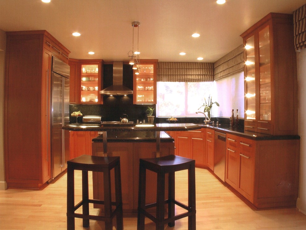 Esempio di una cucina minimal di medie dimensioni con lavello a doppia vasca, ante in legno scuro, top in granito, paraspruzzi verde, elettrodomestici in acciaio inossidabile e parquet chiaro