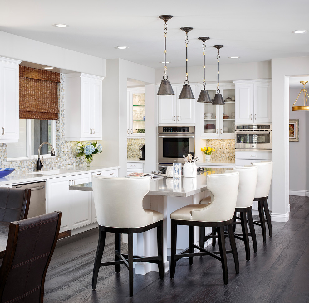 Kitchen - transitional dark wood floor and black floor kitchen idea in Los Angeles with an undermount sink, recessed-panel cabinets, white cabinets, quartzite countertops, multicolored backsplash, glass tile backsplash, stainless steel appliances, an island and gray countertops