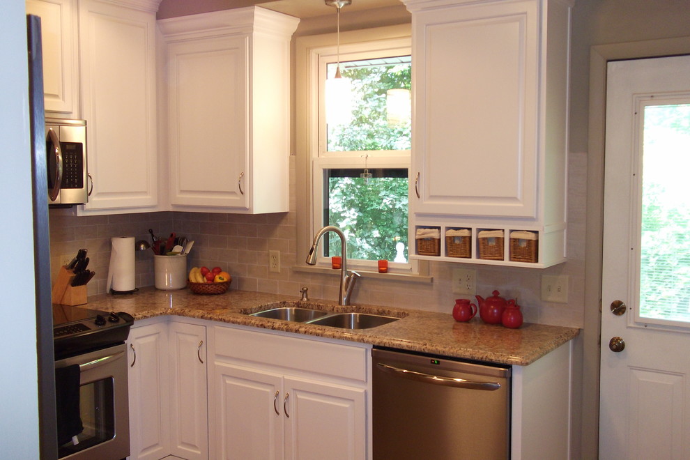 Example of a small classic l-shaped medium tone wood floor enclosed kitchen design in Other with an undermount sink, raised-panel cabinets, white cabinets, granite countertops, beige backsplash, ceramic backsplash, stainless steel appliances and no island