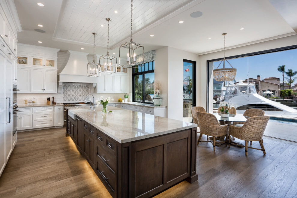 Inspiration for a traditional u-shaped kitchen/diner in Orange County with a belfast sink, shaker cabinets, white cabinets, white splashback, stainless steel appliances, medium hardwood flooring, an island, brown floors, beige worktops, a timber clad ceiling and a drop ceiling.