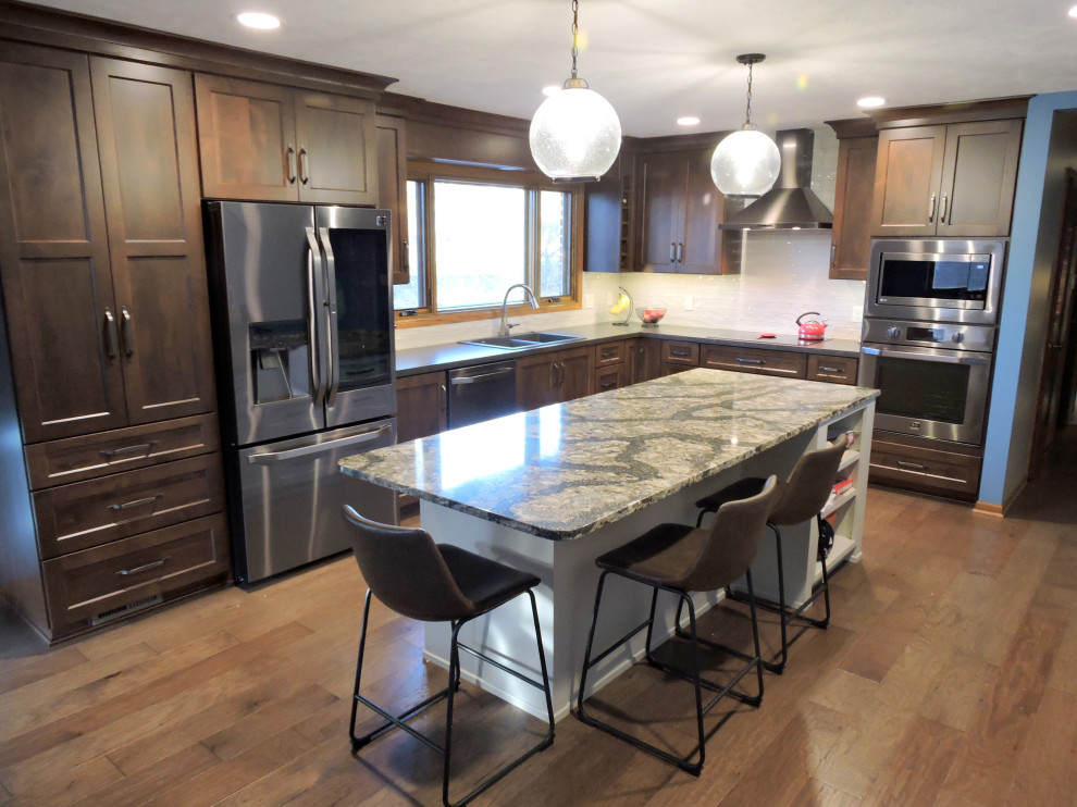 Idéer för att renovera ett vintage grå grått kök och matrum, med en dubbel diskho, luckor med infälld panel, skåp i mörkt trä, laminatbänkskiva, vitt stänkskydd, stänkskydd i keramik, rostfria vitvaror, mellanmörkt trägolv, en köksö och brunt golv