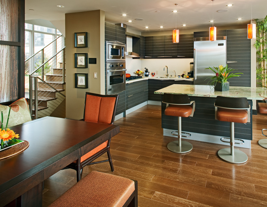Inspiration for a mid-sized contemporary l-shaped medium tone wood floor and brown floor eat-in kitchen remodel in San Diego with a drop-in sink, flat-panel cabinets, gray cabinets, granite countertops, stainless steel appliances and an island