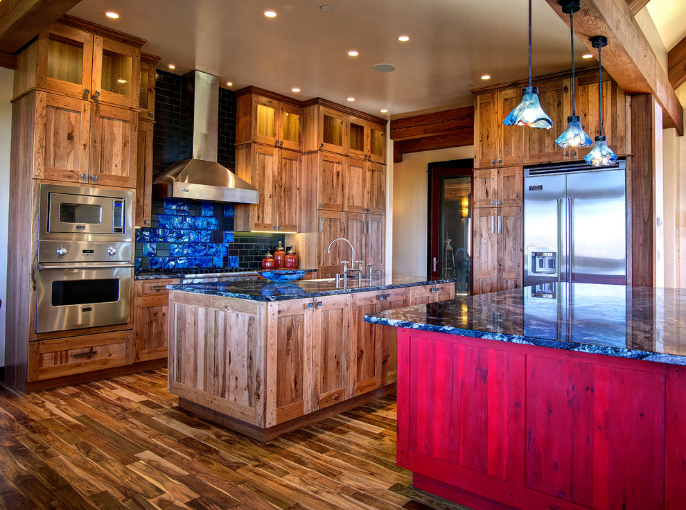 Bild på ett stort rustikt kök, med en undermonterad diskho, skåp i shakerstil, skåp i mellenmörkt trä, granitbänkskiva, flerfärgad stänkskydd, stänkskydd i glaskakel, rostfria vitvaror, mellanmörkt trägolv och flera köksöar