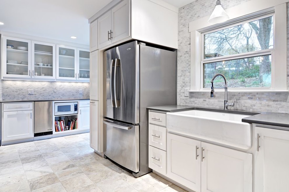 Example of a trendy kitchen design in Austin with stone tile backsplash, stainless steel appliances, a farmhouse sink, white backsplash, white cabinets and shaker cabinets