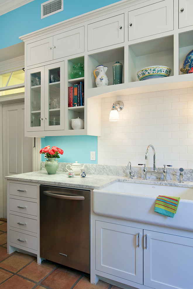 Elegant galley terra-cotta tile eat-in kitchen photo in Austin with a farmhouse sink, flat-panel cabinets, white cabinets, marble countertops, blue backsplash, stainless steel appliances and ceramic backsplash