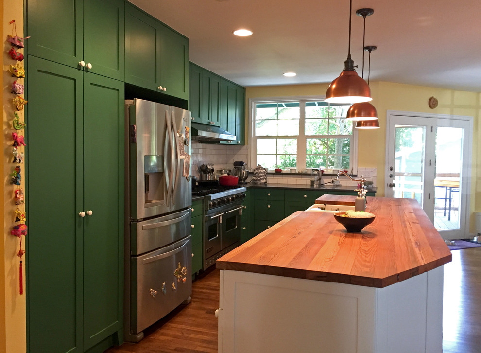 Modern inredning av ett stort kök, med vitt stänkskydd, stänkskydd i tunnelbanekakel, rostfria vitvaror, mellanmörkt trägolv, en köksö, en rustik diskho, skåp i shakerstil, gröna skåp, träbänkskiva och brunt golv