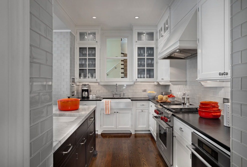 Inspiration for a transitional kitchen remodel in Chicago with a farmhouse sink, quartzite countertops, gray backsplash, glass tile backsplash and stainless steel appliances