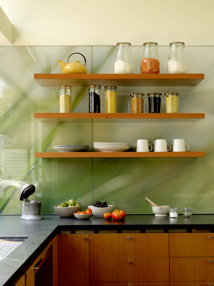 Foto di una cucina moderna con nessun'anta, ante in legno scuro, paraspruzzi con lastra di vetro, lavello sottopiano, paraspruzzi verde e elettrodomestici in acciaio inossidabile