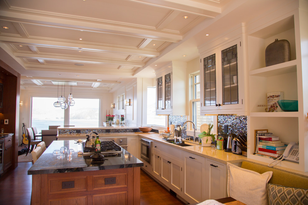 Immagine di una cucina costiera di medie dimensioni con ante di vetro, ante bianche, paraspruzzi marrone e elettrodomestici in acciaio inossidabile