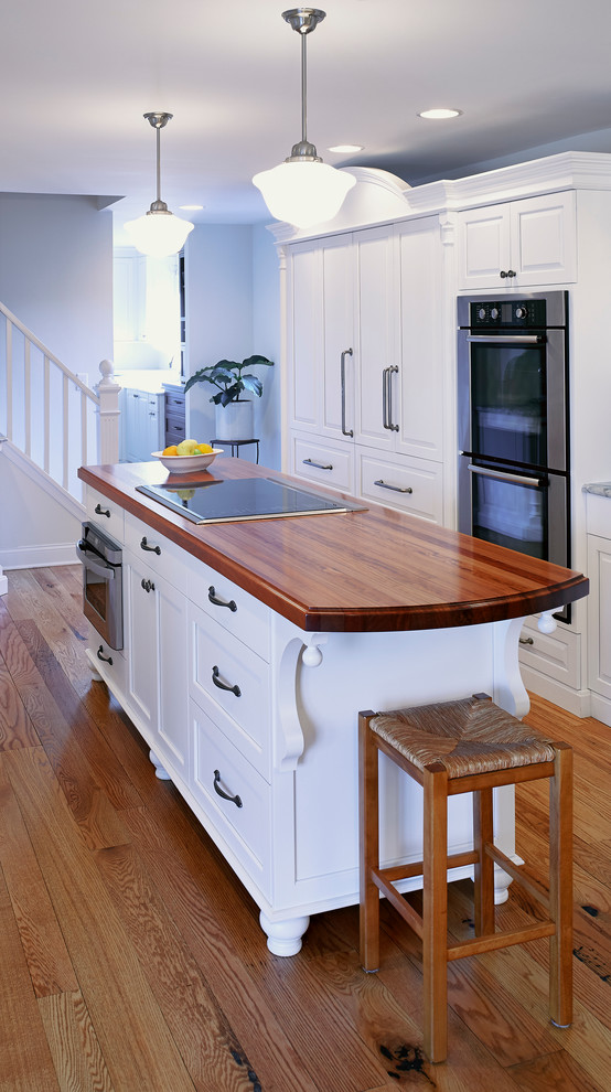 Foto de cocina campestre de tamaño medio cerrada con armarios estilo shaker, puertas de armario blancas, encimera de madera, suelo de madera en tonos medios y una isla