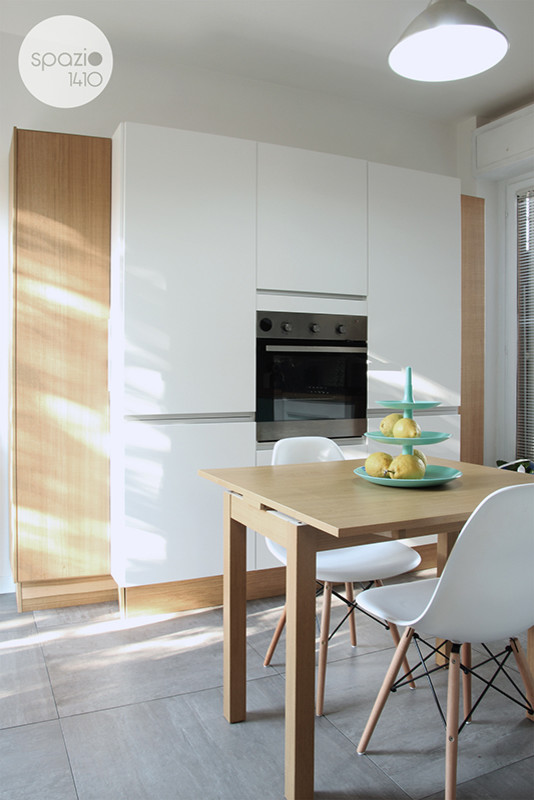 Mittelgroße Moderne Wohnküche ohne Insel in L-Form mit weißen Schränken, Küchenrückwand in Grau und Keramikboden in Rom