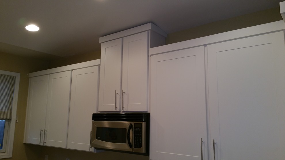 This is an example of a modern kitchen in Phoenix with a submerged sink, shaker cabinets, quartz worktops, stainless steel appliances and porcelain flooring.