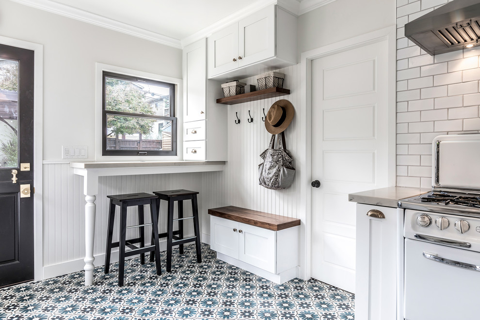 Design ideas for a medium sized rural galley enclosed kitchen in Los Angeles with white cabinets, marble worktops, white splashback, ceramic splashback, white appliances, cement flooring, no island, multi-coloured floors, a belfast sink and shaker cabinets.