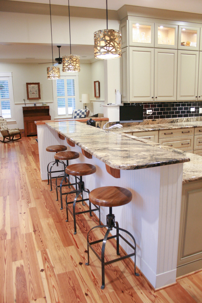 Foto di un cucina con isola centrale stile americano di medie dimensioni con elettrodomestici in acciaio inossidabile e pavimento in legno massello medio