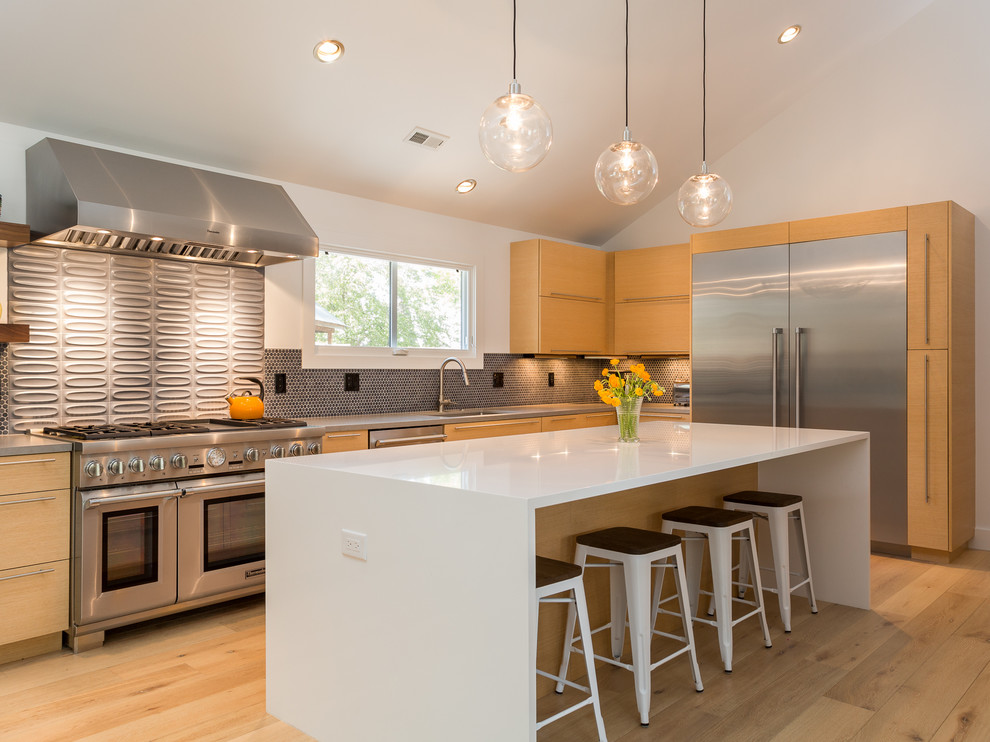 Offene Moderne Küche in L-Form mit flächenbündigen Schrankfronten, hellbraunen Holzschränken, braunem Holzboden, Kücheninsel und Küchenrückwand in Grau in Denver