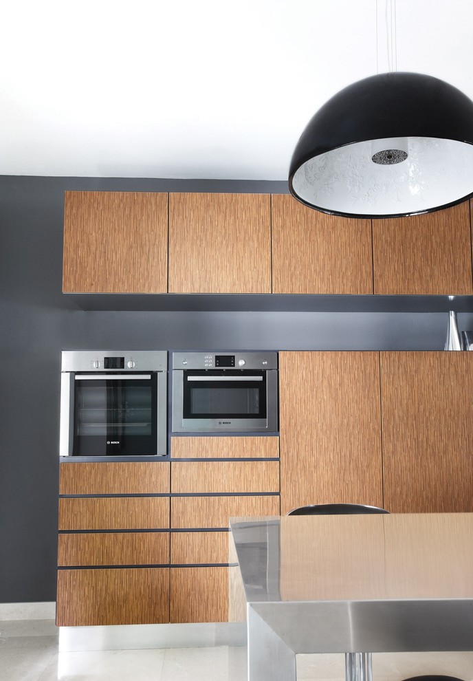 Idéer för ett mellanstort modernt grå kök, med en integrerad diskho, luckor med upphöjd panel, skåp i ljust trä, bänkskiva i rostfritt stål, grått stänkskydd, glaspanel som stänkskydd, rostfria vitvaror, marmorgolv, en köksö och beiget golv