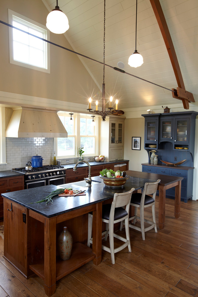 Klassische Küche mit Landhausspüle, Küchenrückwand in Weiß, Rückwand aus Metrofliesen und schwarzen Elektrogeräten in Minneapolis