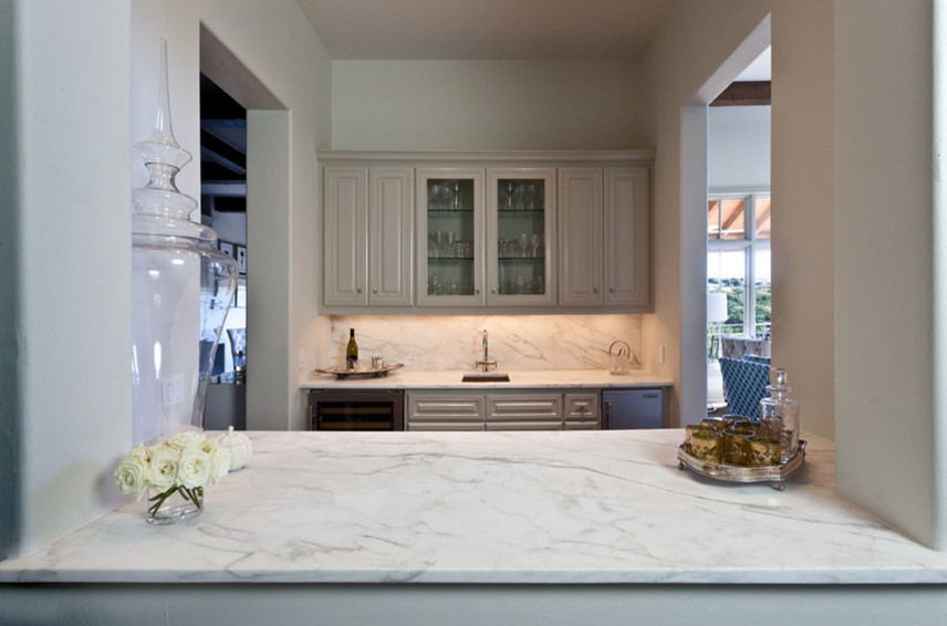 Mid-sized transitional galley enclosed kitchen photo in Nashville with an undermount sink, raised-panel cabinets, gray cabinets, marble countertops, white backsplash, stone slab backsplash and stainless steel appliances
