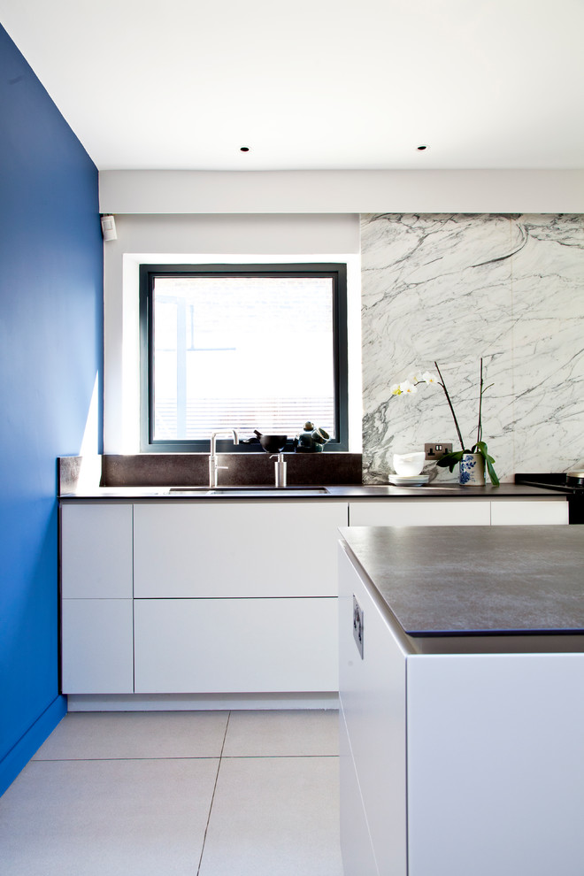 Foto di una grande cucina minimalista con lavello a doppia vasca, ante lisce, paraspruzzi bianco, paraspruzzi in marmo, elettrodomestici in acciaio inossidabile, pavimento bianco e top nero