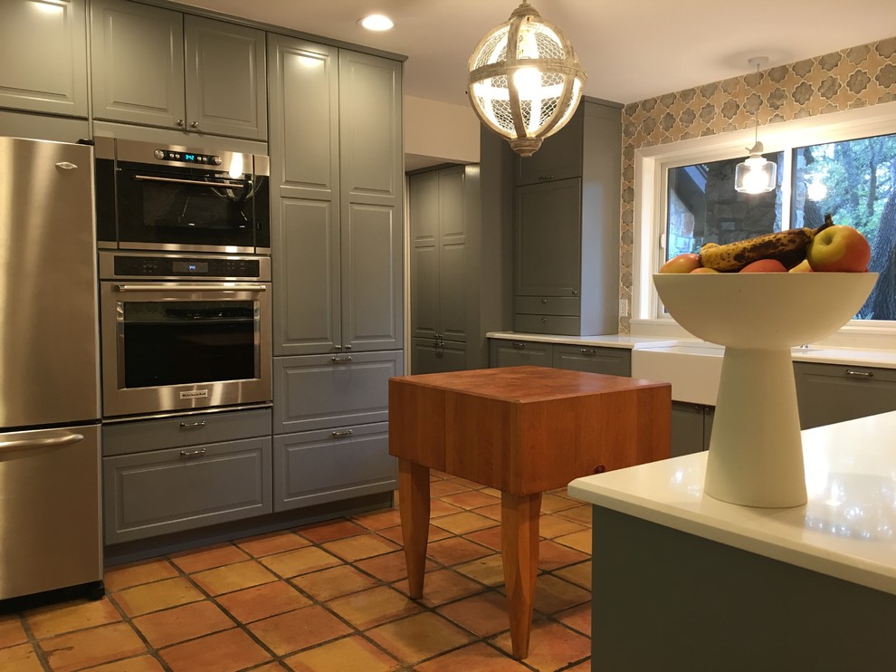 Example of a mid-sized arts and crafts l-shaped terra-cotta tile and brown floor enclosed kitchen design in Austin with a farmhouse sink, raised-panel cabinets, gray cabinets, quartzite countertops, multicolored backsplash, ceramic backsplash, stainless steel appliances and no island