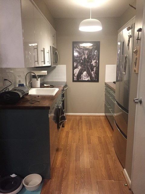ニューヨークにあるお手頃価格の小さなコンテンポラリースタイルのおしゃれなキッチン (ドロップインシンク、フラットパネル扉のキャビネット、ターコイズのキャビネット、木材カウンター、白いキッチンパネル、セラミックタイルのキッチンパネル、シルバーの調理設備、ラミネートの床、アイランドなし、茶色い床) の写真
