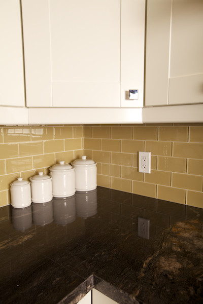 Immagine di una cucina classica con lavello a doppia vasca, ante in stile shaker, ante bianche, top in granito, paraspruzzi beige e pavimento in legno massello medio