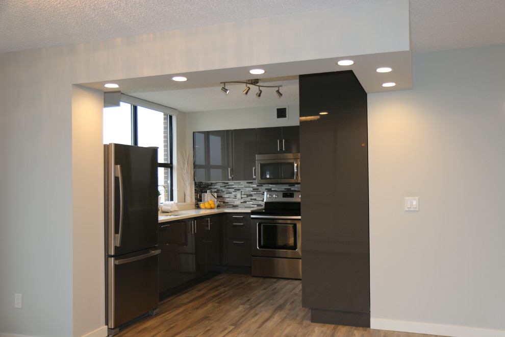 Exempel på ett litet modernt kök, med en undermonterad diskho, släta luckor, grå skåp, bänkskiva i kvartsit, grått stänkskydd, stänkskydd i glaskakel, rostfria vitvaror och ljust trägolv