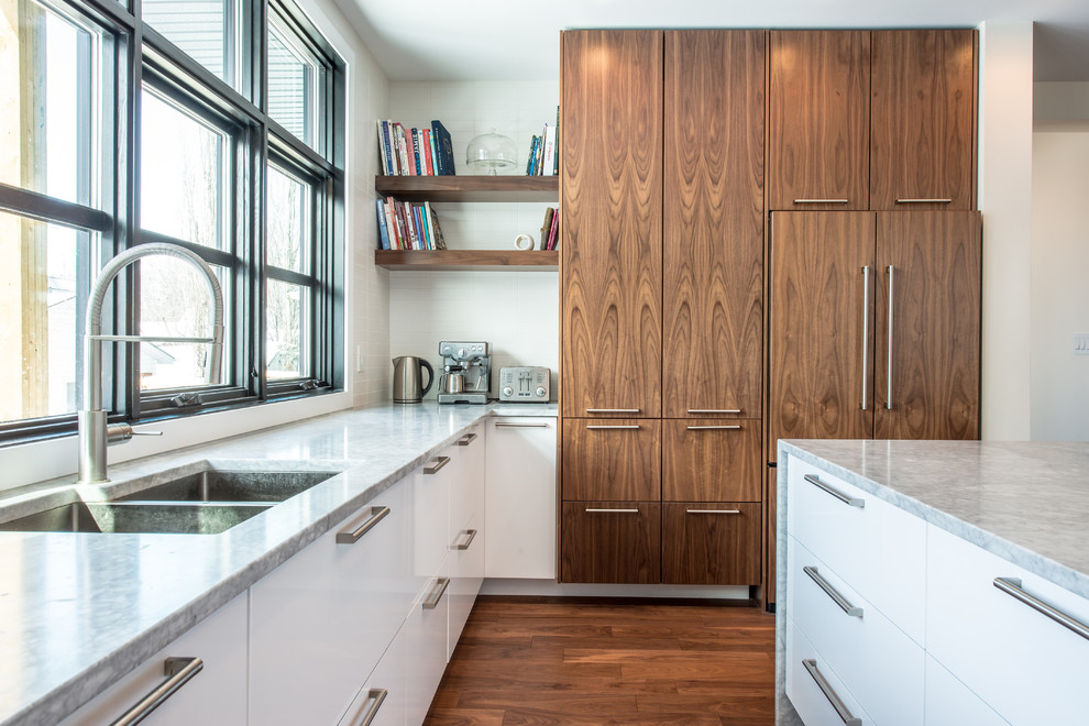 Medium sized contemporary u-shaped kitchen in Edmonton with a built-in sink, flat-panel cabinets, medium wood cabinets, marble worktops, white splashback, ceramic splashback, integrated appliances, medium hardwood flooring and an island.