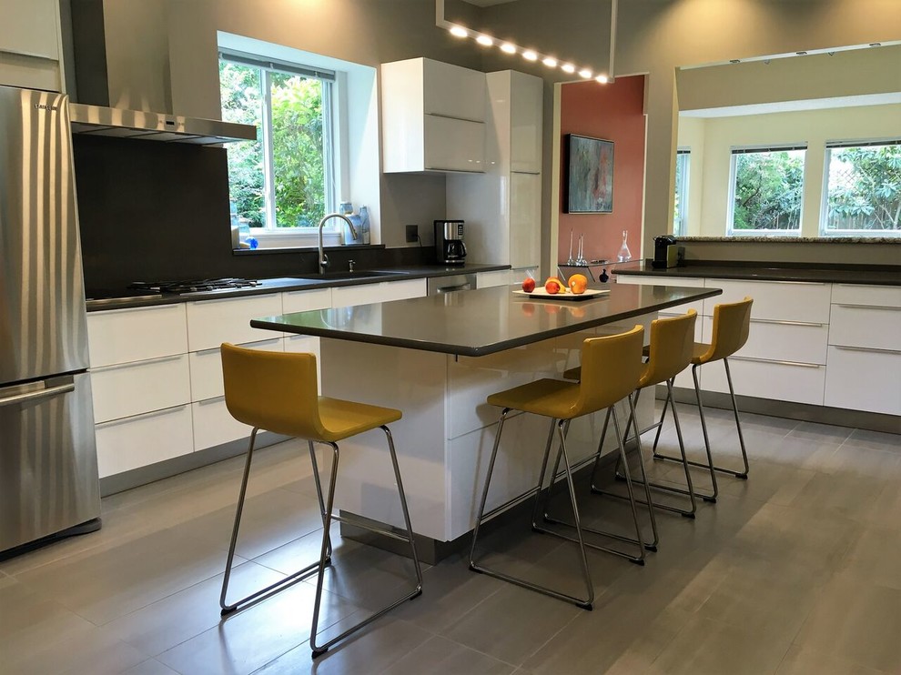 Mid-sized modern u-shaped eat-in kitchen in Austin with an undermount sink, flat-panel cabinets, white cabinets, black splashback, stone slab splashback, stainless steel appliances, with island and grey floor.