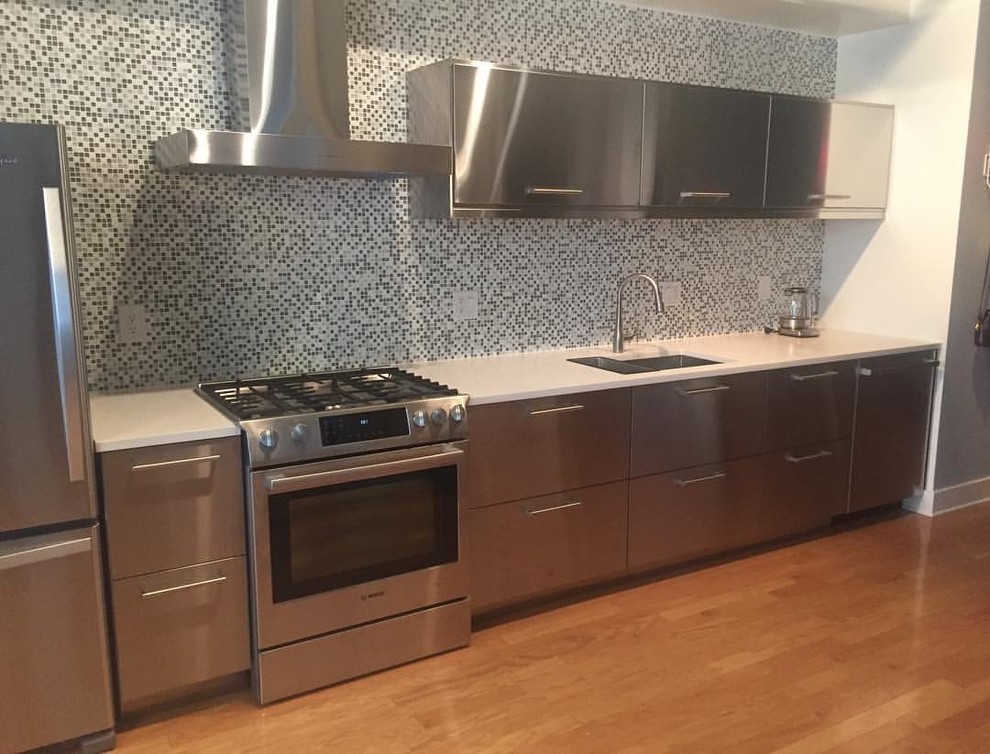 Foto på ett mellanstort funkis kök, med en undermonterad diskho, släta luckor, skåp i rostfritt stål, bänkskiva i kvarts, flerfärgad stänkskydd, stänkskydd i mosaik och rostfria vitvaror