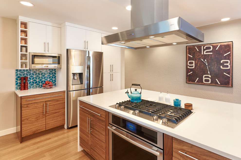 Inspiration for a mid-sized contemporary single-wall medium tone wood floor and brown floor open concept kitchen remodel in Denver with a single-bowl sink, flat-panel cabinets, white cabinets, quartz countertops, blue backsplash, mosaic tile backsplash, stainless steel appliances and an island