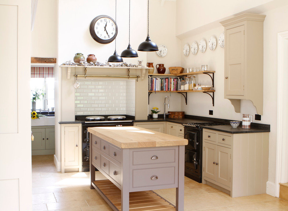 Design ideas for a farmhouse kitchen in West Midlands with shaker cabinets, granite worktops, white splashback, metro tiled splashback, travertine flooring and black appliances.