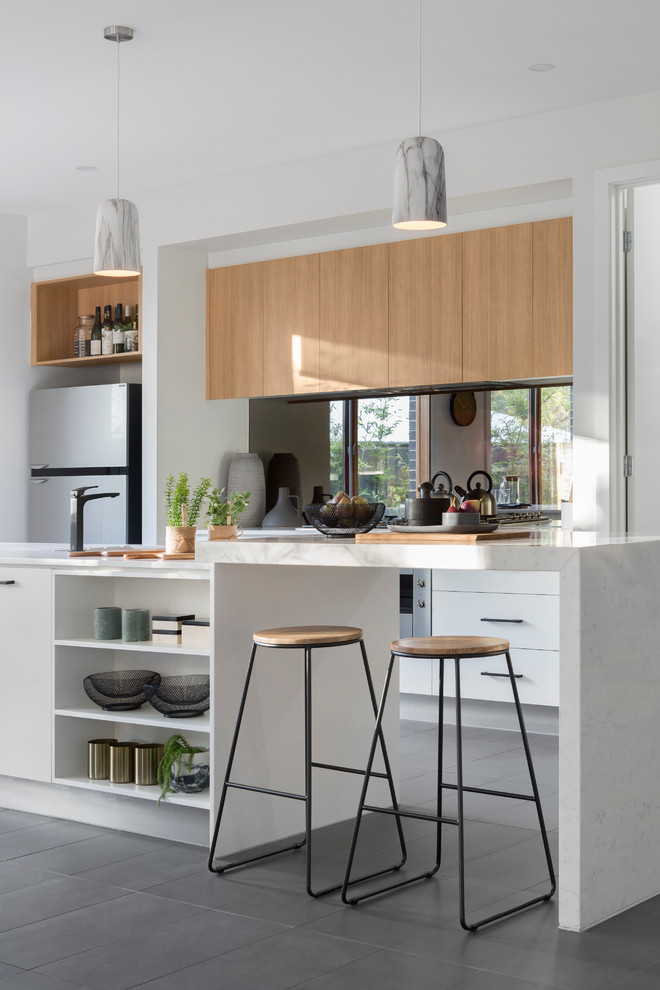 Inspiration for a contemporary kitchen in Melbourne with flat-panel cabinets, light wood cabinets and an island.