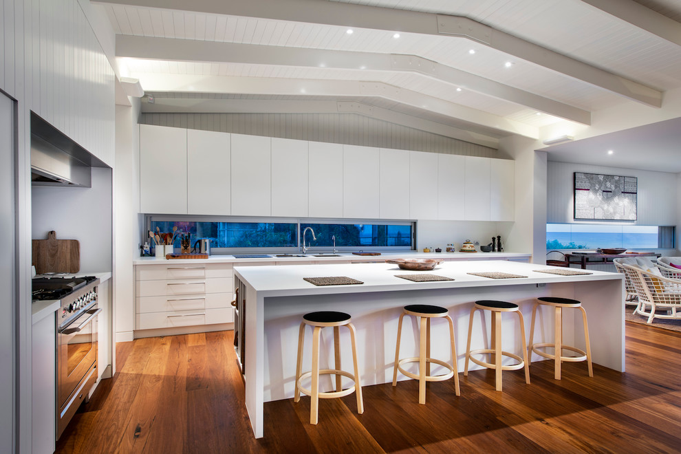 パースにあるコンテンポラリースタイルのおしゃれなキッチン (フラットパネル扉のキャビネット、白いキャビネット、シルバーの調理設備、濃色無垢フローリング) の写真