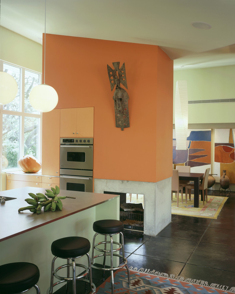 Inspiration for a 1960s kitchen remodel in Austin with flat-panel cabinets and orange cabinets