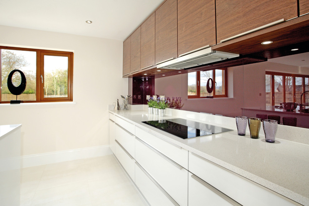 Immagine di una grande cucina design con ante lisce, ante bianche, top in superficie solida, paraspruzzi con lastra di vetro e elettrodomestici da incasso
