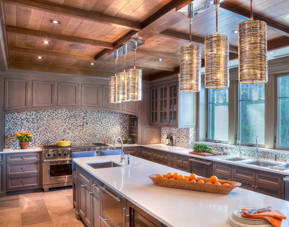 Photo of an expansive traditional u-shaped kitchen/diner in Burlington with recessed-panel cabinets, grey cabinets, stainless steel appliances, an island, a double-bowl sink, composite countertops, multi-coloured splashback, mosaic tiled splashback, porcelain flooring and brown floors.
