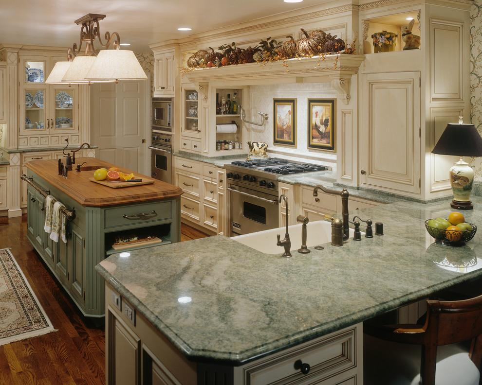 Eat-in kitchen - large traditional u-shaped dark wood floor eat-in kitchen idea in San Diego with a farmhouse sink, beaded inset cabinets, granite countertops, multicolored backsplash, stone tile backsplash, stainless steel appliances and an island
