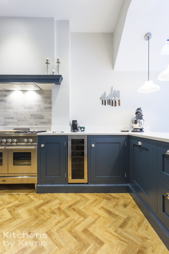 Design ideas for a medium sized classic u-shaped open plan kitchen in Cheshire with a single-bowl sink, blue cabinets, quartz worktops, blue splashback, marble splashback, stainless steel appliances, vinyl flooring, a breakfast bar, white worktops and shaker cabinets.
