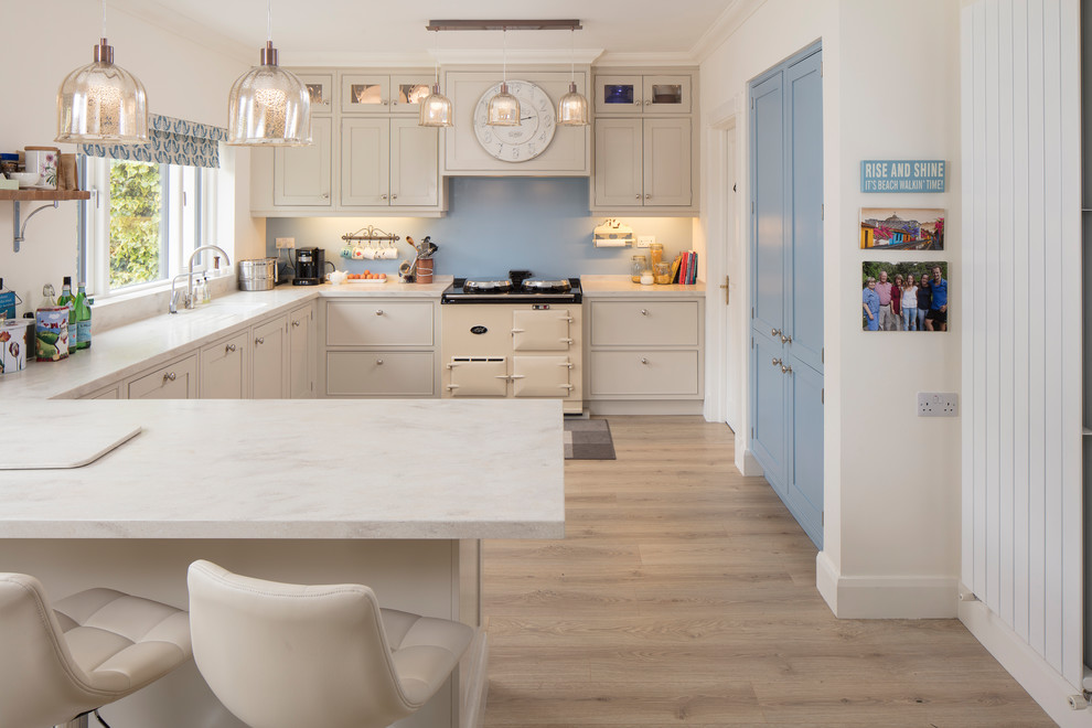 Photo of a country l-shaped kitchen/diner in Other with shaker cabinets, blue splashback and a breakfast bar.
