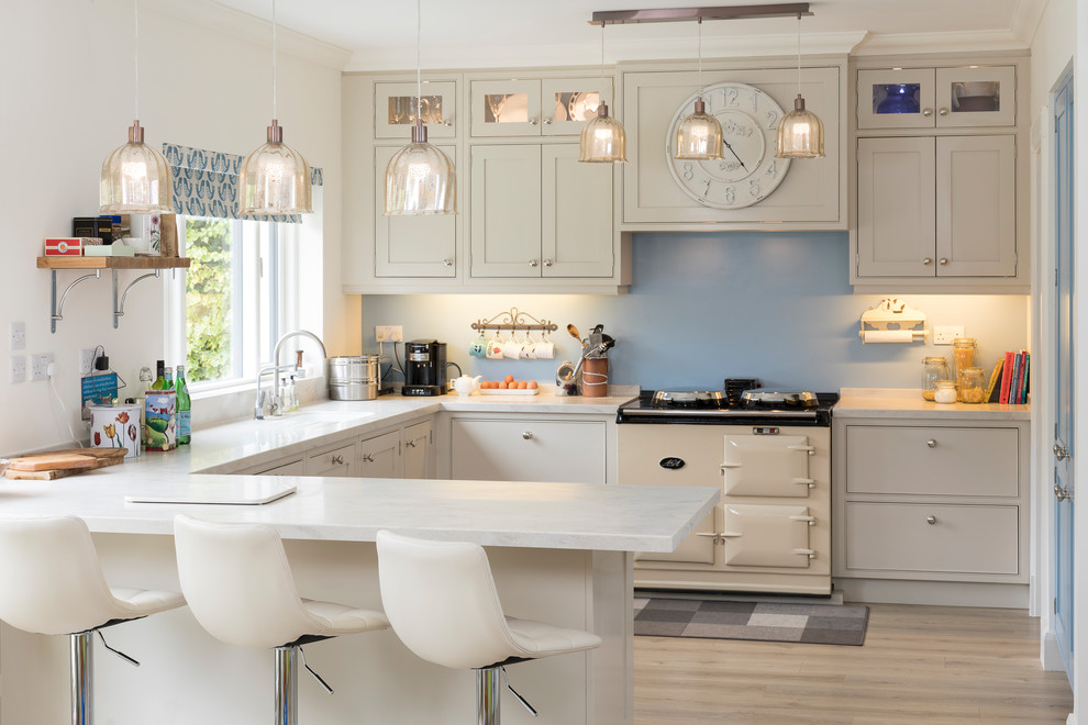 На фото: кухня-гостиная среднего размера в классическом стиле с фасадами в стиле шейкер, бежевыми фасадами, синим фартуком, цветной техникой, светлым паркетным полом и бежевым полом