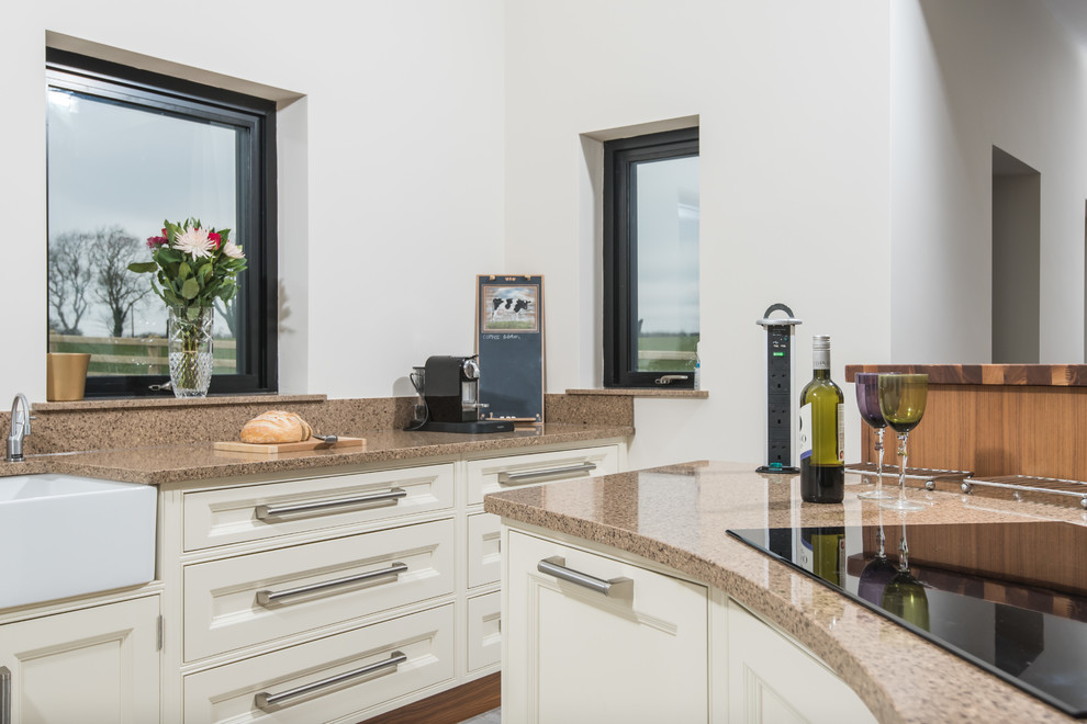 Photo of a large contemporary l-shaped open plan kitchen in Belfast with a belfast sink, beaded cabinets, white cabinets, granite worktops, stainless steel appliances, porcelain flooring, an island, white floors and multicoloured worktops.